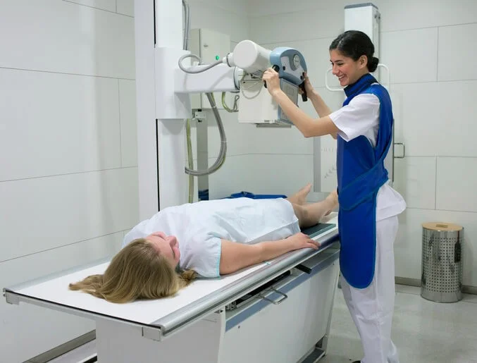 Técnica tomando una radiografía a una paciente